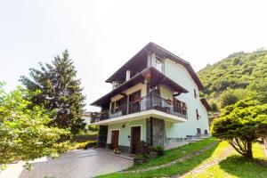 uma casa branca com varanda e árvores em Dory's apartment em Arquata Scrivia