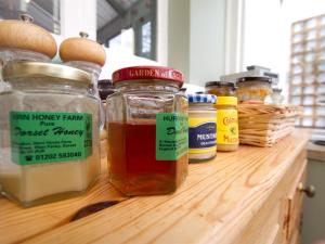 un bancone con barattoli di miele su un ripiano in legno di Westwood House a Dorchester