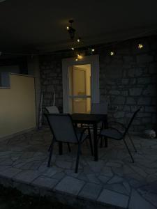 uma mesa e cadeiras num pátio à noite em Apartman Delać em Tivat