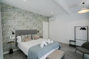1 dormitorio con 1 cama grande y 1 silla en Lujoso apartamento con piscina compartida 2 en Sevilla