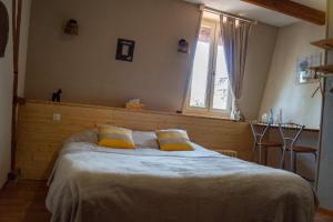 a bedroom with a large bed with two yellow pillows at Au Cheval Noir in Quaëdypre