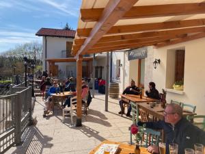 a group of people sitting at tables at a restaurant at Locanda 77 in Borso del Grappa