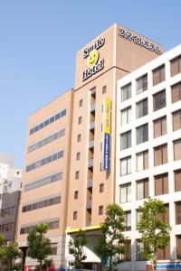 a large building with a sign on the side of it at Smile Hotel Tokyo Nihonbashi in Tokyo