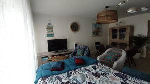 Sala de estar con cama y TV en Appartement T3 de 74m2 très lumineux vue panoramique mer et plages en Concarneau