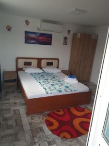 a bedroom with a bed and a rug at La Dragalasu in Corbu