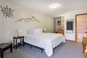 a bedroom with a large bed and a bathroom at The Pioneer Motel in Palmer
