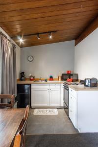 uma cozinha com armários brancos e um tecto de madeira em The Pioneer Motel em Palmer