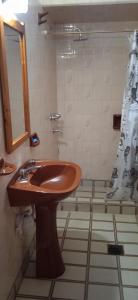 a bathroom with a brown sink and a shower at Lo de la Nercida in Tornquist +9 photos