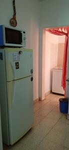a kitchen with a microwave on top of a refrigerator at Lo de la Nercida in Tornquist