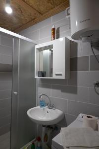 a white bathroom with a sink and a mirror at Apartman Delać in Tivat