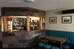 uma sala de jantar com uma mesa e bancos azuis em Scalloway Hotel em Scalloway