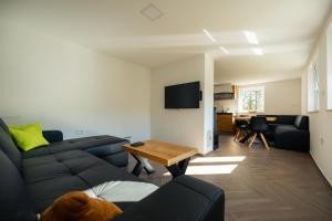 een woonkamer met een bank en een tafel bij Holiday House Chilly in Kotlje