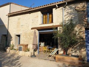 uma casa com um pátio com uma mesa e um guarda-chuva em La Remise des Amis - Maison rénovée au calme em Peyriac-de-Mer