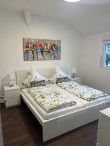 a bedroom with a white bed with a painting on the wall at Stauffenberg Apartments in Albstadt