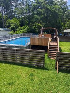 a pool in a yard with two benches and a fence at Cozy Barn with Pool Access & Near Lake Conroe in Montgomery