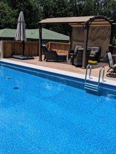a swimming pool with chairs and a gazebo at Cozy Barn with Pool Access & Near Lake Conroe in Montgomery