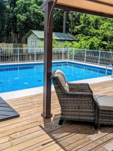 a wicker chair sitting under an umbrella next to a swimming pool at Cozy Barn with Pool Access & Near Lake Conroe in Montgomery +37 photos