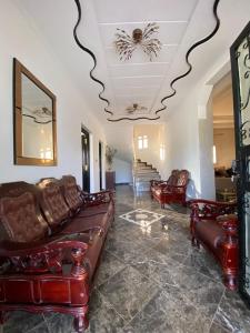 a living room with leather furniture and a ceiling at Vila Haja - Beautiful Farmhouse with a Private Pool! in Imouzzer Kandar
