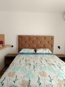 um quarto com uma cama com uma colcha e almofadas em Apartmani Maša em Budva