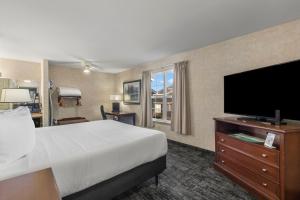 um quarto de hotel com uma cama e uma televisão de ecrã plano em Beach House Inn em Fort Bragg