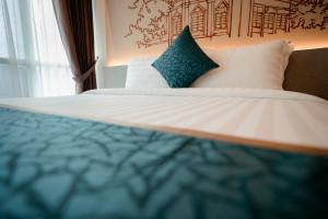 Uma cama ou camas num quarto em The Rangoon Hotel