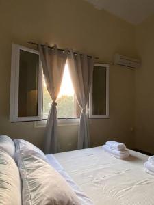 a bedroom with a bed and a window with curtains at CASA DI SARDI (main square of Kos) in Kos Town