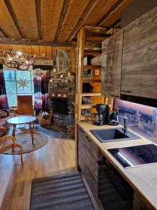 a kitchen and living room with a table and a fireplace at Korpikelo in Ylläsjärvi