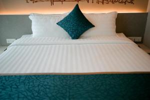 Uma cama ou camas num quarto em The Rangoon Hotel