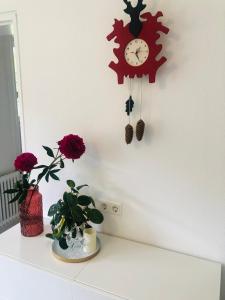 un orologio appeso a un muro con dei fiori su un bancone di Haus Anna-Marie a Feldberg