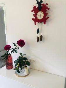 a clock hanging on a wall with flowers on a counter at Haus Anna-Marie in Feldberg