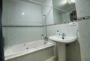 W łazience znajduje się umywalka, wanna i umywalka. w obiekcie APARTAMENTO AVELINA w mieście Monforte de Lemos +7 zdjęć
