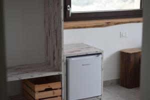 een kleine koelkast in een kamer met een raam bij b&b Adamà in Atena Lucana