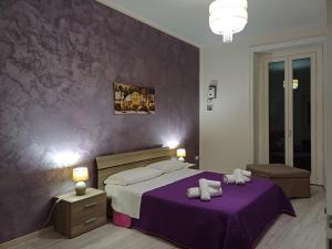 a bedroom with a purple wall with a bed at Casa Anna Maria in Marsala