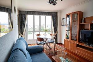 salon z niebieską kanapą i stołem w obiekcie APARTAMENTO AVELINA w mieście Monforte de Lemos
