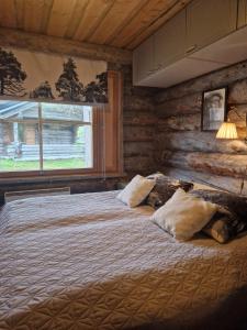 a bedroom with a bed in a log cabin at Korpikelo in Ylläsjärvi