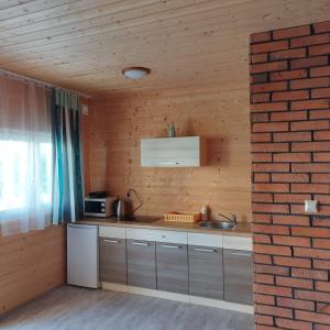 a kitchen with a sink and a brick wall at Domki Letniskowe Meduza in Jarosławiec