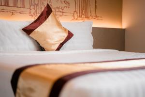 Uma cama ou camas num quarto em The Rangoon Hotel