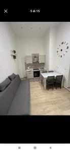 ein Wohnzimmer mit einer Couch und einer Uhr an der Wand in der Unterkunft CASA VACANZE IL FONDACO in Giovinazzo