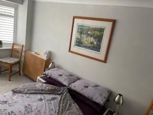 a bedroom with a bed and a picture on the wall at Private Double en-suite Room at the Groves in Kent