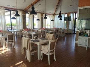 a dining room with tables and chairs and windows at Иссык-Куль,Частный таунхаус-всего минута до пляжа в ЦО "Karven Four Seasons" Issyk-Kul in Chon-Sary-Oy