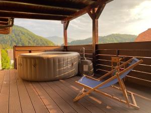 a chair sitting on a deck next to a hot tub at Apartma LIMA in Mozirje