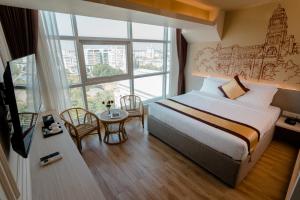 Uma cama ou camas num quarto em The Rangoon Hotel