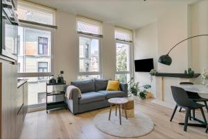 a living room with a couch and a table at New renovated condo's @ trendy south in Antwerp
