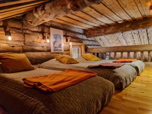 ein Zimmer mit drei Betten in einer Blockhütte in der Unterkunft Korpikelo in Ylläsjärvi