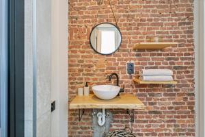 a bathroom with a sink and a brick wall at New renovated condo's @ trendy south in Antwerp +9 photos