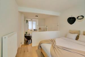 a white bedroom with a bed and a desk at New renovated condo's @ trendy south in Antwerp