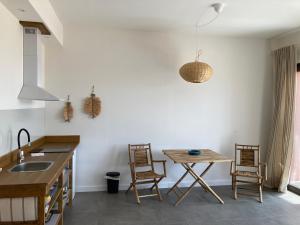 a kitchen with a table and chairs and a sink at La Cobija Apartamentos - Solo Adultos in Ciudad Real