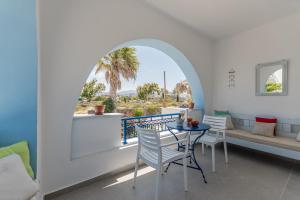 a room with a balcony with a table and chairs at Arhontiko in Naxos Chora