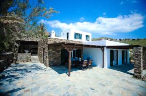Cette maison dispose d'une terrasse avec une table et un parasol. dans l'établissement Villa Melydia, à Koundouros