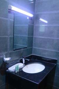 a bathroom with a sink and a mirror at Alezz Suites Salalah in Salalah